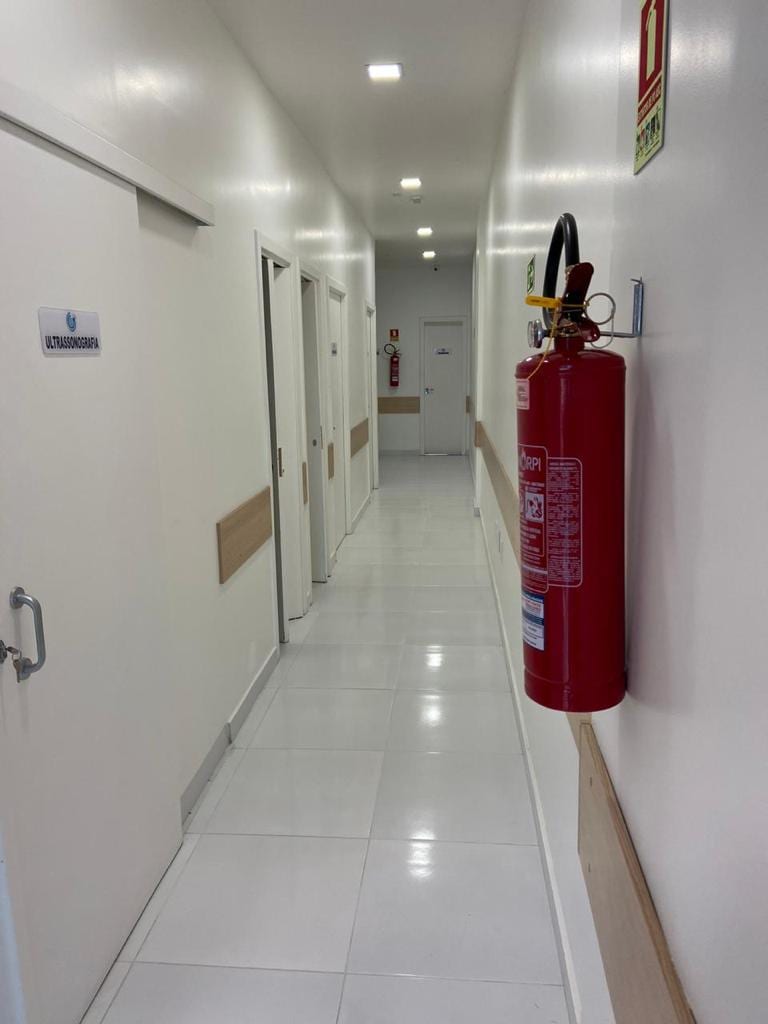 Corredor interno da clínica dando acesso às salas de ultrassonografia